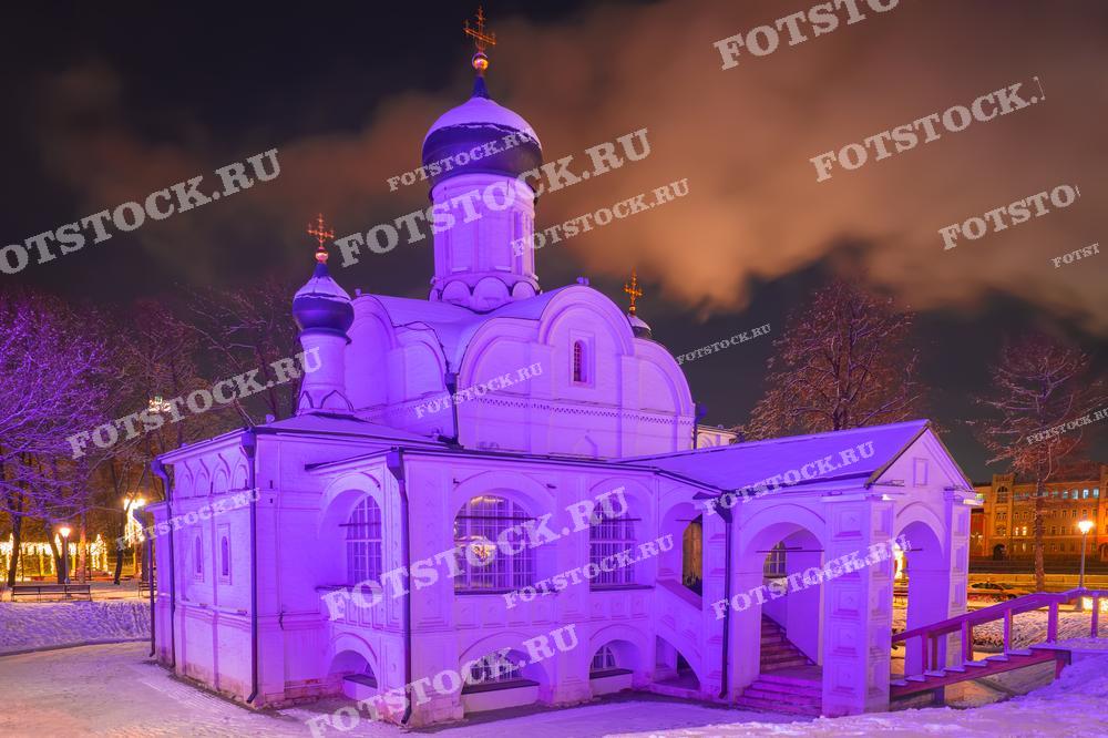На фотографии изображена одна из церквей Москвы, расположенная на территории Парка Зарядье. Подсветка создает мягкое фиолетовое освещение, подчеркивающее архитектурные линии постройки.